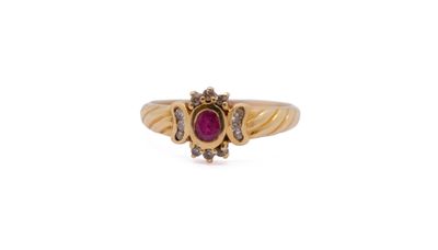 a close up of a gold ring with a ruby stone