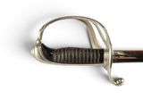a close up of a sword on a white surface