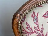 a chair with a floral upholstered back and a wooden frame