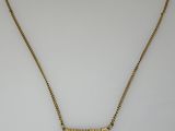 un collier plaqué or sur lequel est gravé le mot « person »