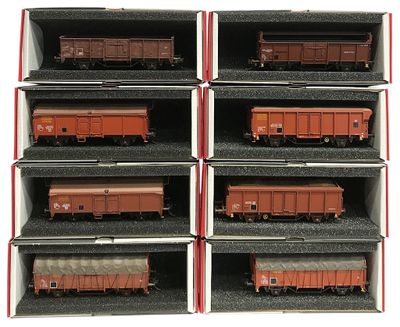 six wagons rouges et noirs dans une boîte posée sur une surface blanche