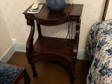 une petite table sur laquelle est posée une lampe, à côté d'un lit