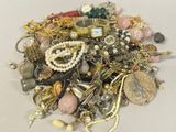 a pile of assorted jewelry on a white surface
