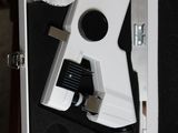 a white camera in a case on a wooden table