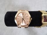 two watches that are sitting on a black stand