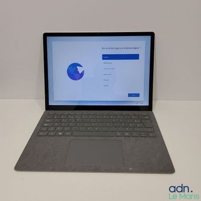 L'ordinateur portable est posé sur la table, l'écran ouvert.