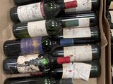 Les bouteilles de vin se trouvent dans un carton posé sur un sol carrelé.