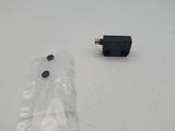 a small black object on a white surface next to a plastic bag