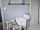 a radiator in the corner of a room next to a toilet
