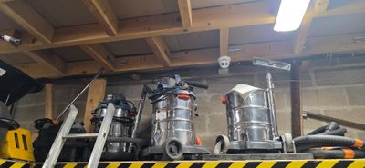 de nombreux modèles d'aspirateurs sur une étagère dans un garage