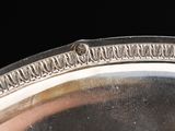 a close up of a silver plate on a black background