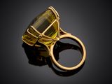 an image of a gold ring with a large green stone
