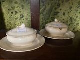 two white dishes on a table with a green wall behind them