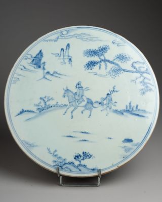 blue and white plate with a man riding a horse and a man on a horse