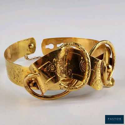 un bracelet en or sur lequel est gravée l'image d'un homme portant un casque