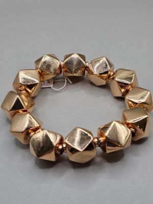 un gros plan sur un bracelet composé de perles en métal doré