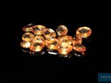 a close up of a bunch of yellow sapphires on a black surface