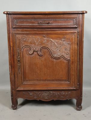 une vieille armoire en bois ornée de sculptures sur la façade et les côtés