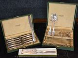two sets of silverware in a box on a table