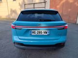 the rear end of a blue car parked in a parking lot