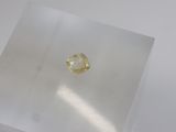 a close up of a yellow diamond sitting on top of a white surface