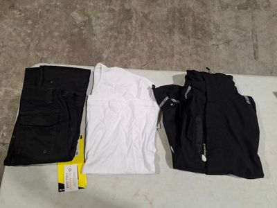 three pairs of black pants and a white t - shirt on a table