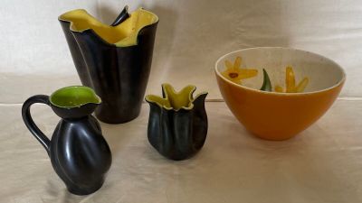 three vases and a bowl sitting on a table
