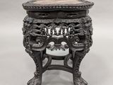 a black table with a marble top and ornate carvings on it