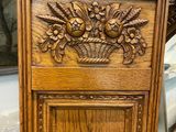 a wooden cabinet with a basket of flowers on it