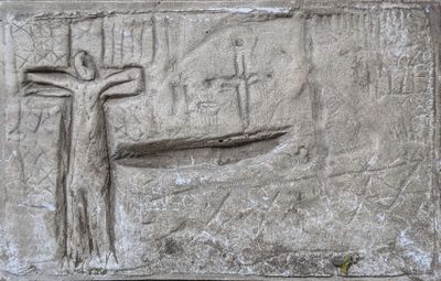 carvings of a man on a cross on a stone wall