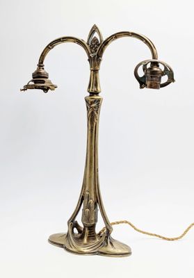 une lampe de table en laiton ancien à laquelle sont fixées deux ampoules