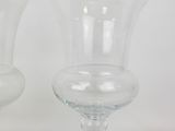 two glass vases sitting next to each other on a table