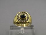 a close up of a gold ring with a black stone surrounded by white diamonds