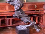 a bronze statue of a bird on top of a desk