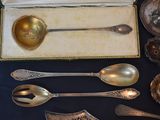 a lot of silver spoons and spoons sitting on a table