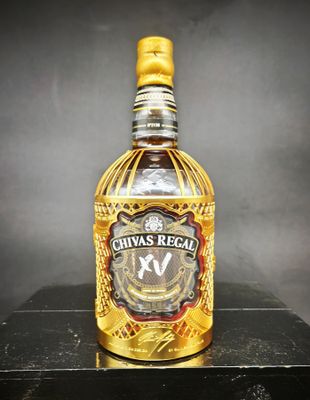 une photo d'une bouteille de Chivas Regal posée sur une table noire