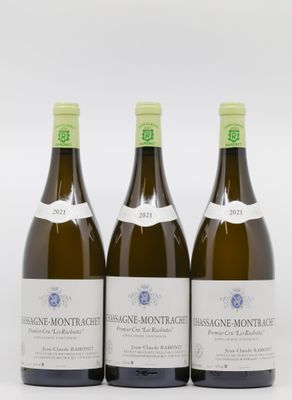 trois bouteilles de vin posées les unes à côté des autres sur une surface blanche