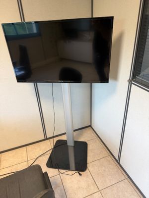 un téléviseur à écran plat sur un support dans le coin d'une pièce