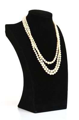 un collier de perles blanches sur un mannequin noir