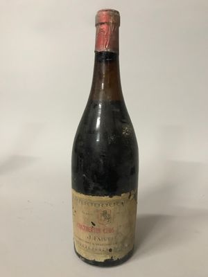 une vieille bouteille de vin posée sur une table blanche