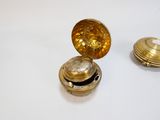 deux petits objets dorés posés sur une surface blanche