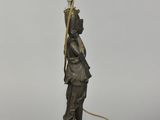 an image of a bronze statue of a man holding a lamp
