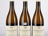 trois bouteilles de vin posées sur une table l'une à côté de l'autre