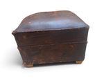 an old wooden box with a leather cover on it