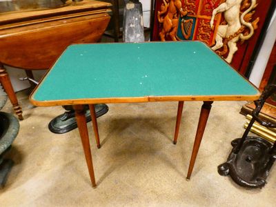 une petite table au plateau vert posée par terre