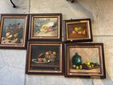 quatre tableaux accrochés au mur d'une pièce où se trouvent une table et une chaise