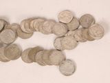 a pile of silver coins on a white surface