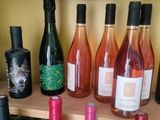 bottles of wine are lined up on a shelf in a room