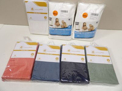 several different colored sheets are sitting on a white table