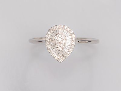 une bague en or blanc sertie d'un diamant taille poire et de diamants taille baguette